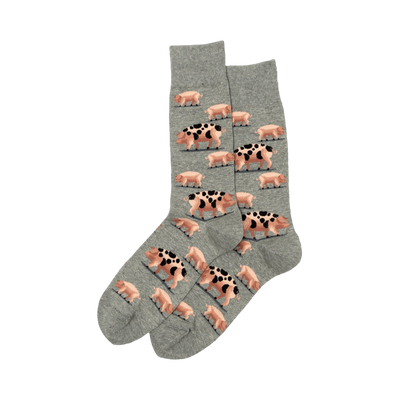 Pair of crew socks. Grey and olive green colors. Design features a repeating pattern of pink pigs with black spots.