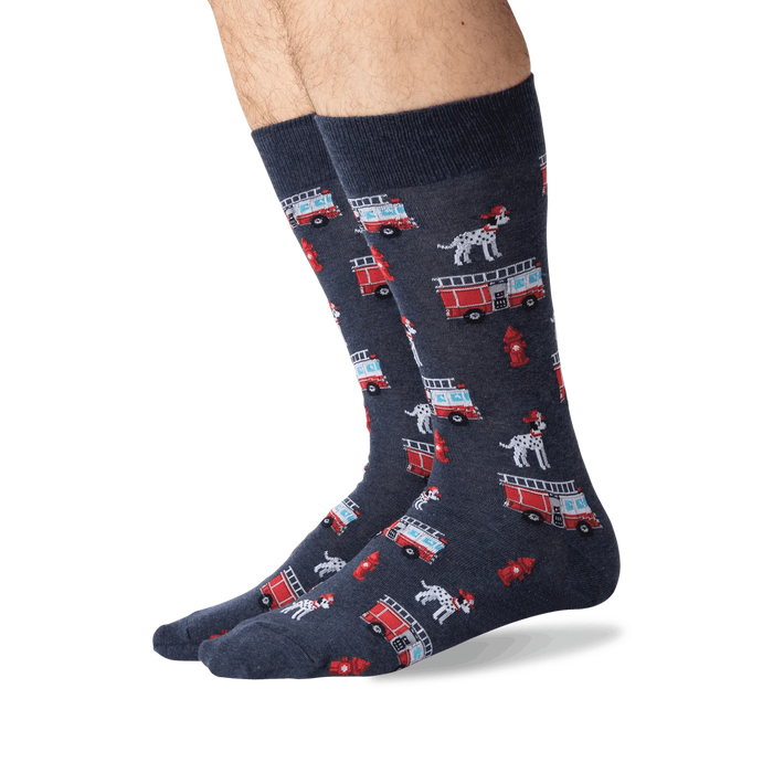 A pair of dark blue socks with a pattern of red fire trucks, black and white dalmatian dogs, and red fire hydrants.