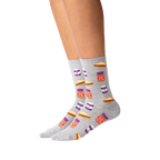 Lifestyle shot of a person wearing a pair of grey Peanut Butter and Jelly crew socks. The socks feature a fun pattern of PB&J sandwiches and jars.