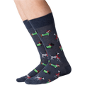 Close-up of a person's legs wearing dark gray Christmas dog socks against a black background.