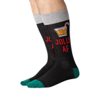 Flat lay of a pair of 'Jolly AF' socks. They are black with green cuffs.
