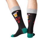 Back view of a person wearing black 'Jolly AF' socks; shows off the full design on the back of the socks.