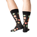 Close-up of a person's legs wearing black Christmas Cookie socks.