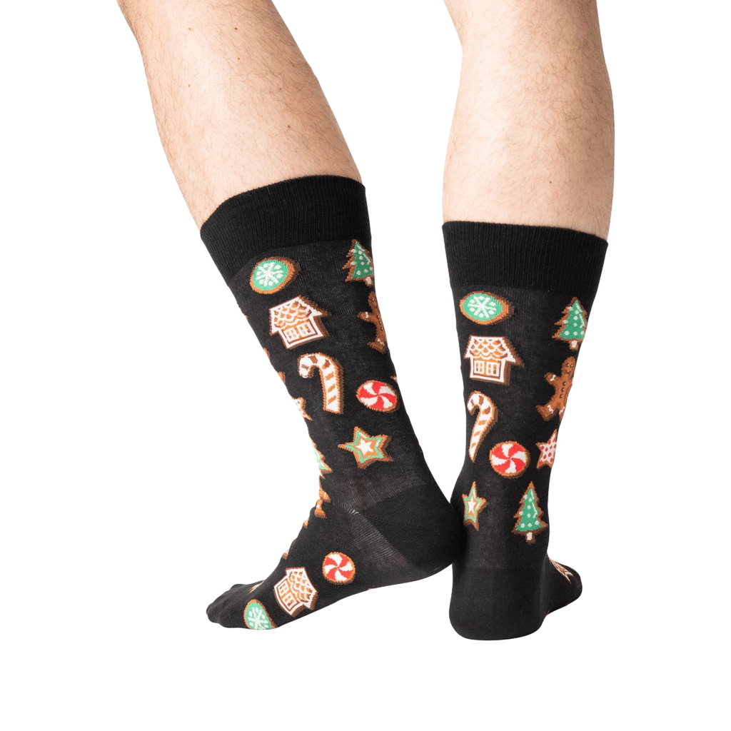 Close-up of a person's legs wearing black Christmas Cookie socks.