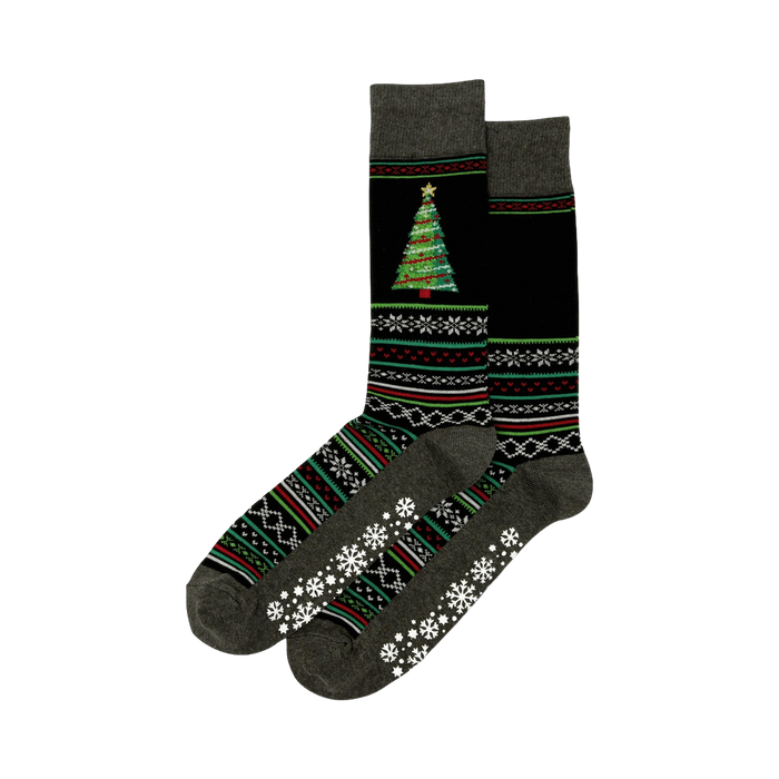 Pair of dark gray and black Christmas tree slipper socks. Features a festive tree, snowflake, and geometric patterns, plus non-skid grips on the soles.