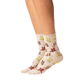 Lifestyle shot showing the socks on a person's legs. The socks are beige with a colorful cowboy boot print.