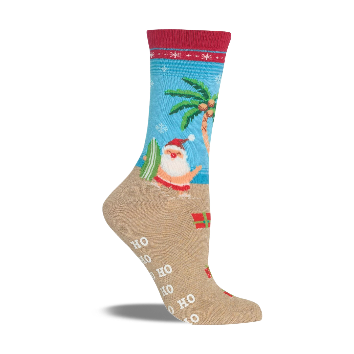 Beige non-skid slipper sock with a red cuff. Features Santa surfing, a palm tree, snowflakes, and presents on a beach scene.