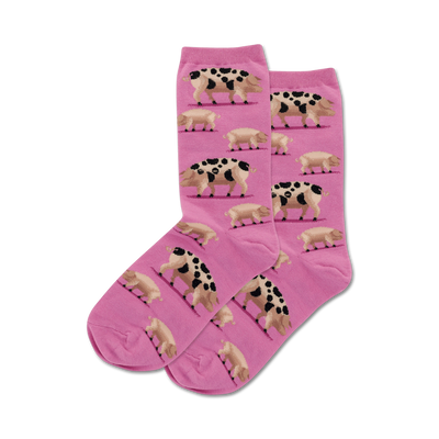 Pair of pink crew socks with a repeating pattern of spotted pigs.  The pigs are brown and black on a light pink background.
