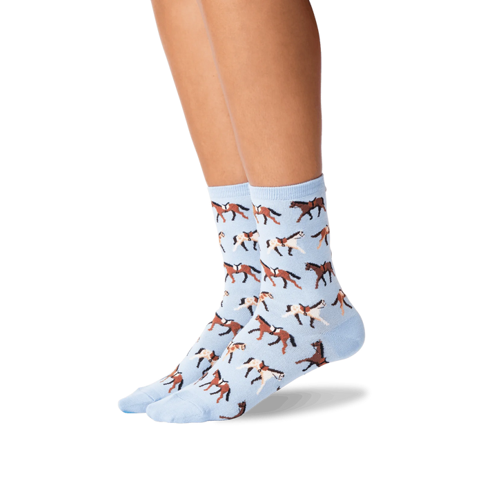 A pair of blue socks with a pattern of brown horses wearing saddles.
