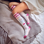 Flatlay product shot of 'Namaste In Bed' socks on a cozy knit blanket. [lf]