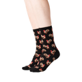 Lifestyle shot of a person's legs wearing black crew socks with a repeating pattern of brown and red turkeys.