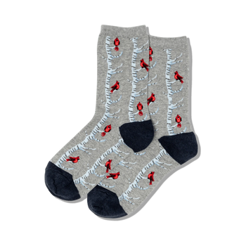 A pair of grey crew socks with a whimsical design of red cardinals on birch trees. The socks have navy blue cuffs.