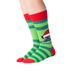 Lifestyle shot showing the socks on a person's feet.  The socks are green and red striped with a pug graphic.