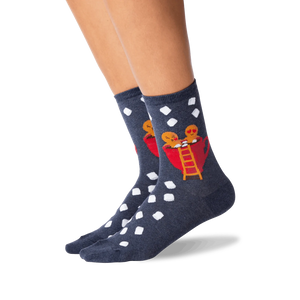 A pair of blue socks with a pattern of white polka dots and a picture of two gingerbread men in a red coffee cup on each sock.