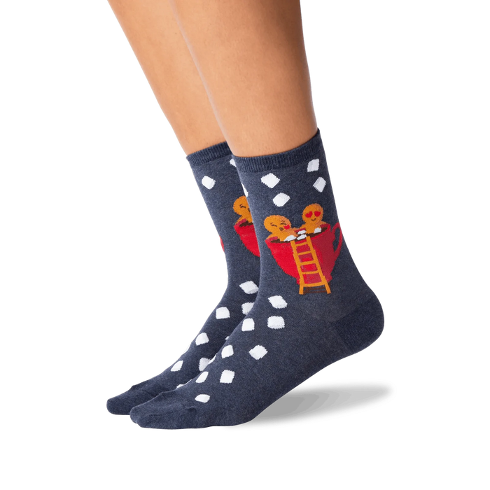 A pair of blue socks with a pattern of white polka dots and a picture of two gingerbread men in a red coffee cup on each sock.