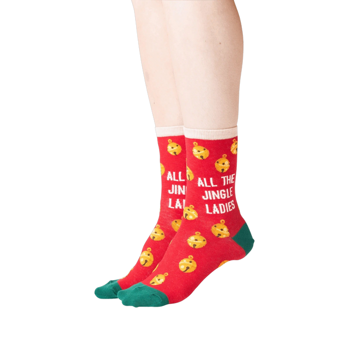 Lifestyle shot showing the socks on a person's feet. The socks are red with gold jingle bells and green cuffs. 