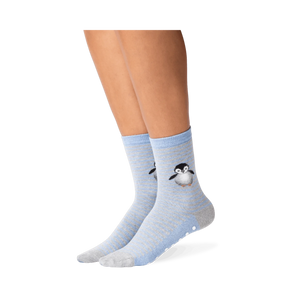 Lifestyle shot showing the penguin socks on a person's legs. The socks are mostly blue and grey, with a subtle striped pattern. A small, embroidered penguin is visible near the ankle area. A good example of how the socks look when worn.