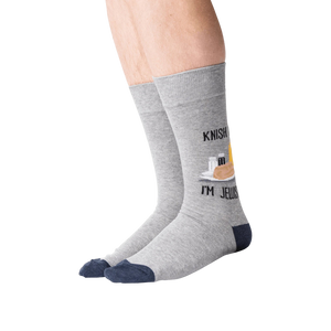 Lifestyle shot of a person wearing the 'Knish Me, I'm Jewish' socks. The socks are gray with a navy blue cuff and feature a knish graphic.