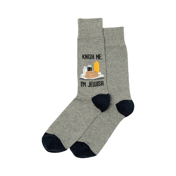 A pair of heather gray crew socks with a navy blue cuff. The socks show a graphic of a knish, mustard, and seasonings with the text 'Knish Me, I'm Jewish'.