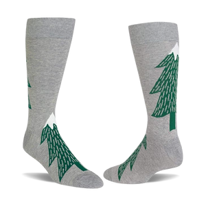 Pair of light gray crew socks with dark green evergreen tree patterns, each tree topped with a white snow peak.