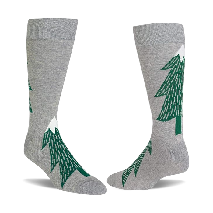 Pair of light gray crew socks with dark green evergreen tree patterns, each tree topped with a white snow peak.