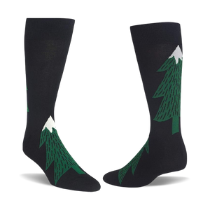 Pair of black crew socks with dark green evergreen tree patterns, each tree topped with a white snow peak.