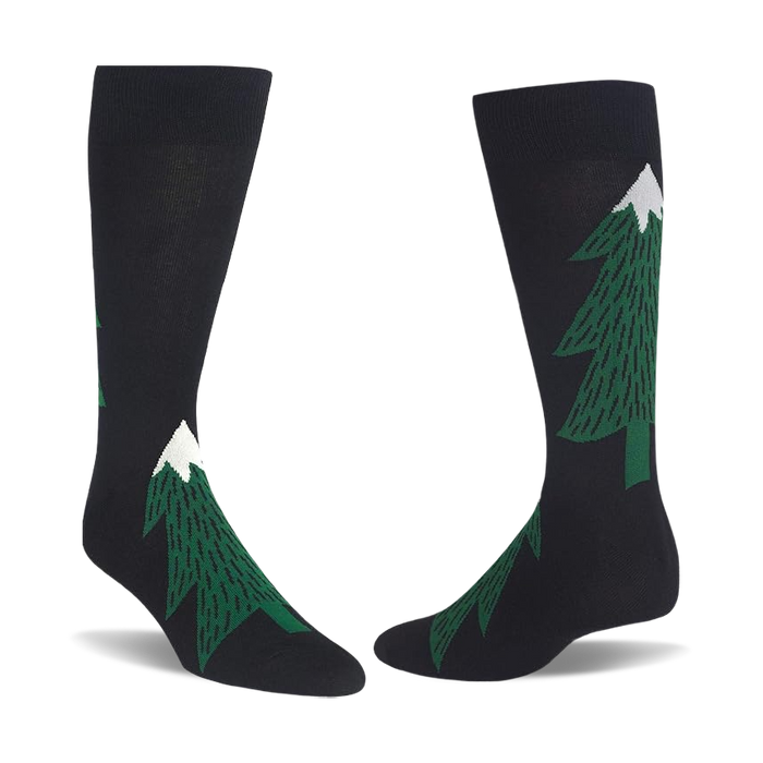 Pair of black crew socks with dark green evergreen tree patterns, each tree topped with a white snow peak.