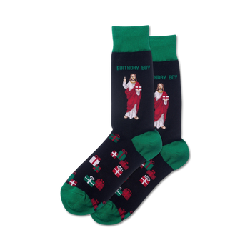 A pair of navy crew socks with green cuffs.  They feature a repeating pattern of Christmas presents and two images of Jesus holding gifts, with the text 'Birthday Boy'.