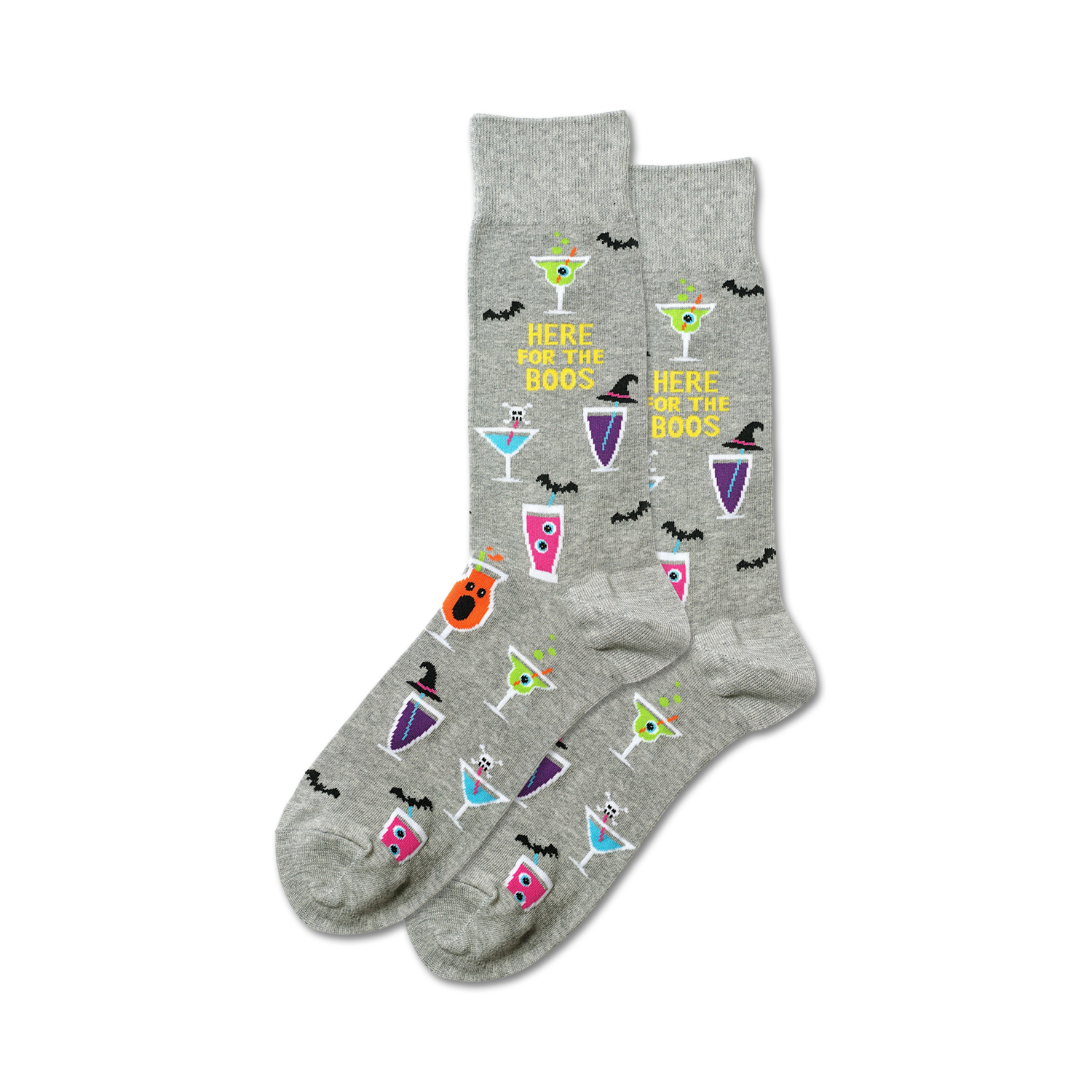 A pair of grey crew socks with a Halloween theme. The socks feature colorful cocktail designs, bats, and the text 'Here For The Boos'.