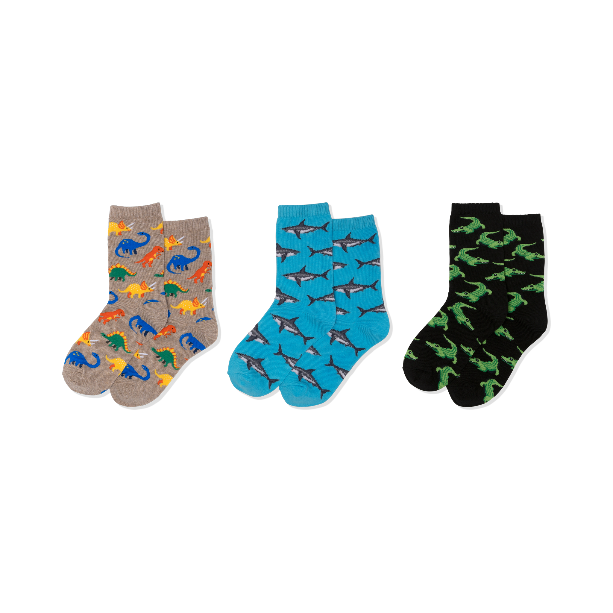 Three pairs of crew socks: one tan with colorful dinosaurs, one blue with grey sharks, and one black with green crocodiles.