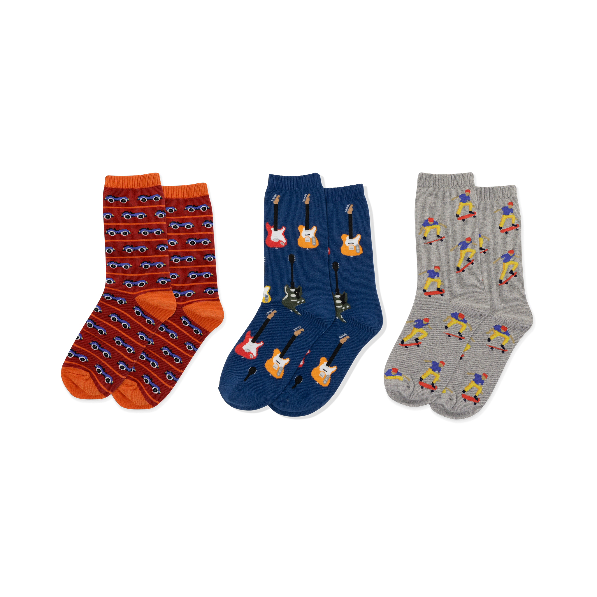 Three pairs of crew socks displayed side-by-side. Left: red-orange with blue cars. Middle: dark blue with colorful electric guitars. Right: light gray with skateboarding figures.