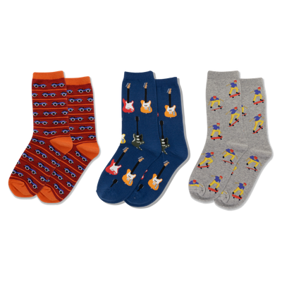 Three pairs of crew socks displayed side-by-side. Left: red-orange with blue cars. Middle: dark blue with colorful electric guitars. Right: light gray with skateboarding figures.