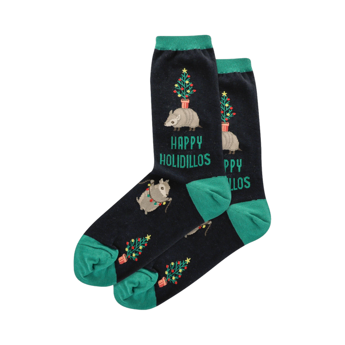 Crew socks in navy blue with teal cuffs.  Design includes armadillos carrying miniature Christmas trees and string lights.  'Happy Holidillos' is printed on the socks. }}