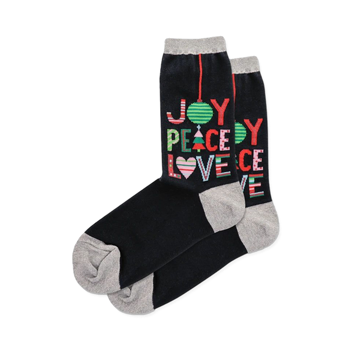 Black crew socks with grey cuffs, heels & toes, printed with colorful 'JOY PEACE LOVE' holiday text & symbols.