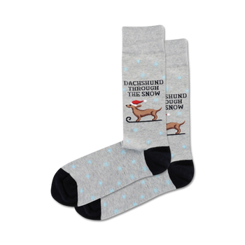 gray men's crew socks with black toes and heels feature a cartoon dachshund in a santa hat walking through snow.   