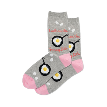 Pair of grey crew socks with black frying pans and fried eggs. Pink toes, white drop shapes, and "Sunny Side" text.