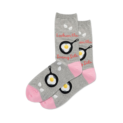 Pair of grey crew socks with black frying pans and fried eggs. Pink toes, white drop shapes, and "Sunny Side" text.