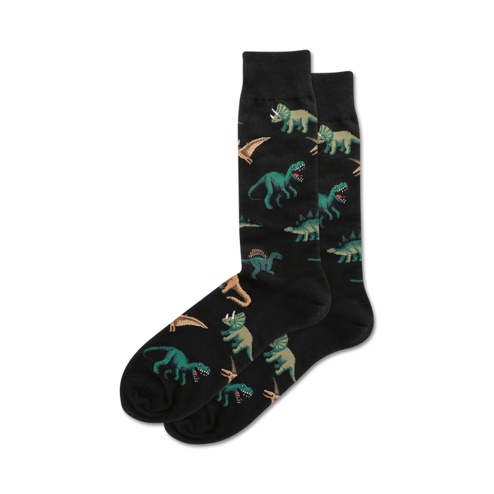 / black crew socks with a pattern of green, brown, and orange dinosaurs including triceratops, pterodactyls, and tyrannosaurus rex. 