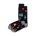 A pair of crew socks in black with a fun 'Happy Me Day' design, featuring colorful party hats, balloons, and streamers.