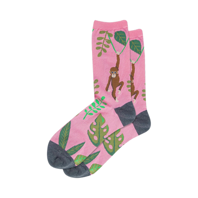 Crew socks, pink base with brown monkeys swinging from vines and green tropical leaves, dark grey heel and toe.