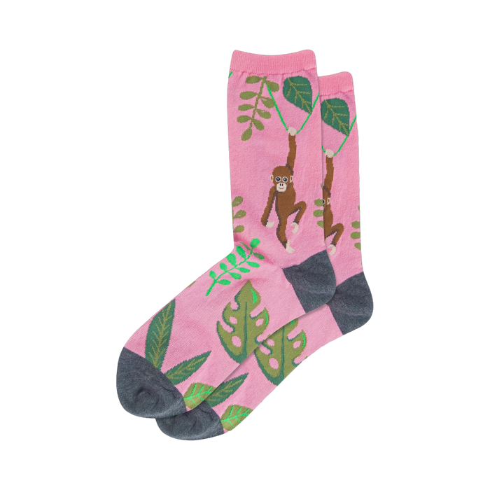 Crew socks, pink base with brown monkeys swinging from vines and green tropical leaves, dark grey heel and toe. }}