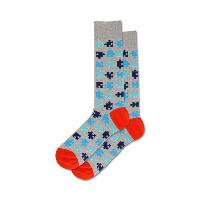 puzzle socks with light gray background, blue and orange puzzle pattern, orange toe and heel, crew length for men.    }}