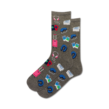 gray crew length novelty socks for women featuring pink luggage, blue headphones, airplane tickets, a neck pillow and a passport.  