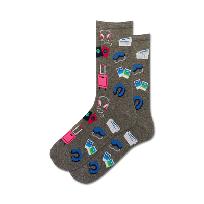 Pair of gray crew socks with colorful travel icons: suitcase, passport, headphones, sleep mask.  Perfect for wanderlusters!
