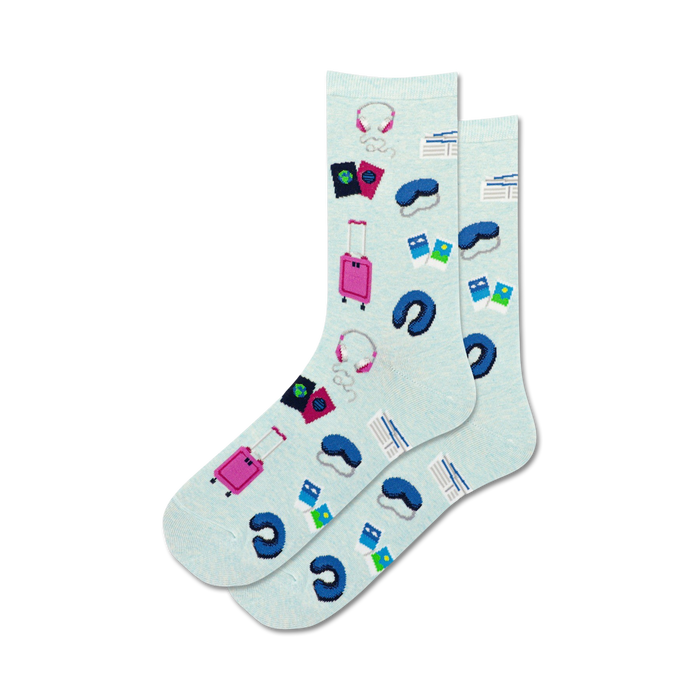 women's travel musts crew socks have a pattern of headphones, luggage, sleep masks, passports, and airplane tickets.  