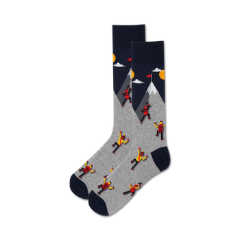 gray crew socks featuring red and yellow mountain climbers on a blue mountain, with a yellow sun and white clouds. men's.  