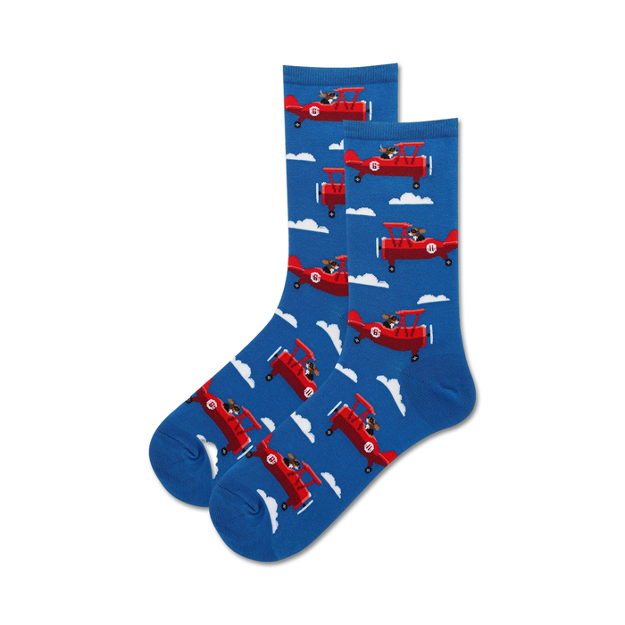 blue women's crew sock with white puffy cloud background and playful dog flying propeller plane.   }}
