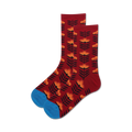 Lifestyle shot:  A pair of burgundy crew socks with an orange retro floral design are casually displayed.