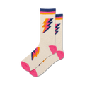 Pair of cream fuzzy crew socks with pink and orange lightning bolt designs. Non-skid grips on the sole.