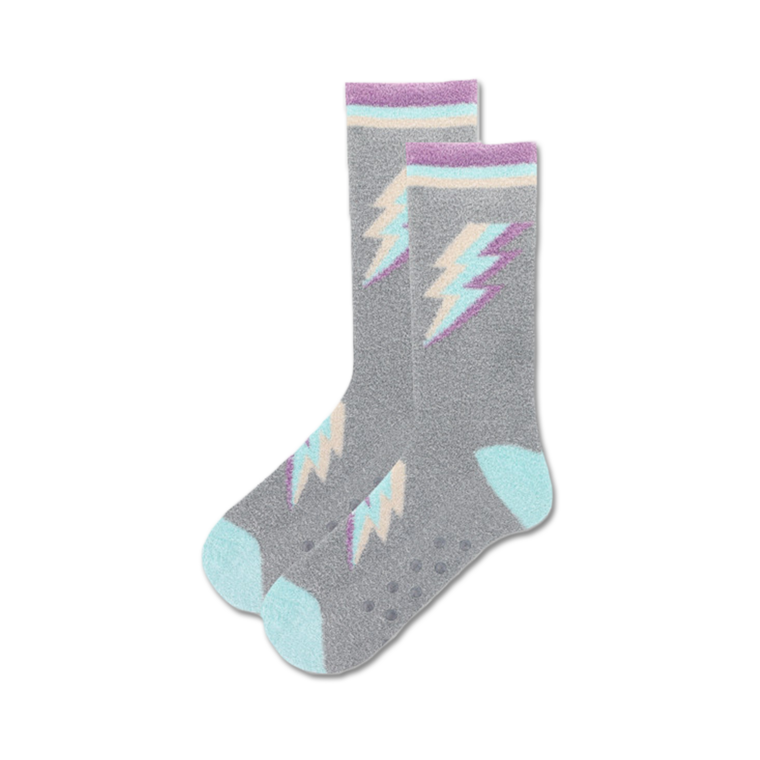 Lifestyle shot of gray fuzzy crew socks with pastel purple and teal lightning bolt designs. Non-skid grips on soles are visible.